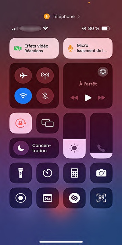 Faire glisser votre doigt du coin supérieur droit vers le bas (ou du bas vers le haut selon le modèle) pour ouvrir le Centre de contrôle et toucher le bouton Micro ou “Téléphone” dans la barre du haut.