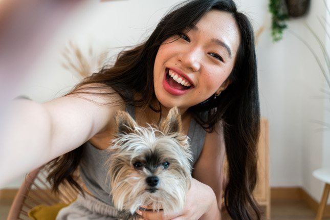 Une femme et son chien posant devant la caméra intérieure