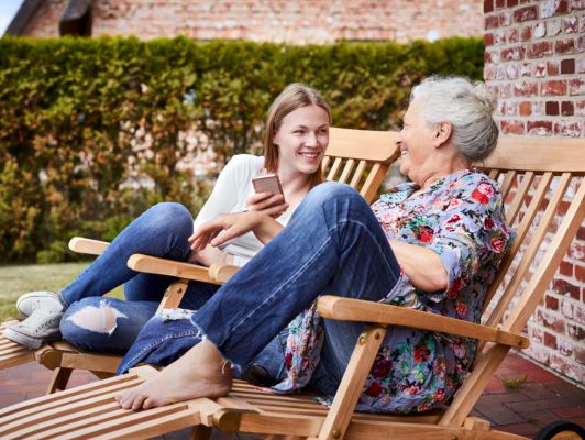 Senior et proche discutant avec un smartphone pour préparer la fin de la 2G et rester joignabl